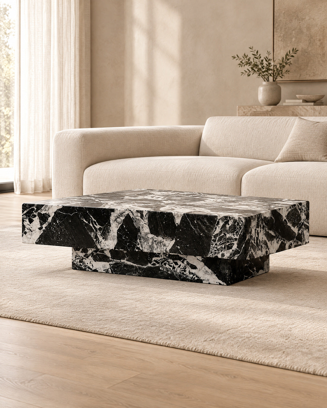 BUTTER coffee table by CARVINGS in Grand Antique Black Marble, in a styled living room, left view.