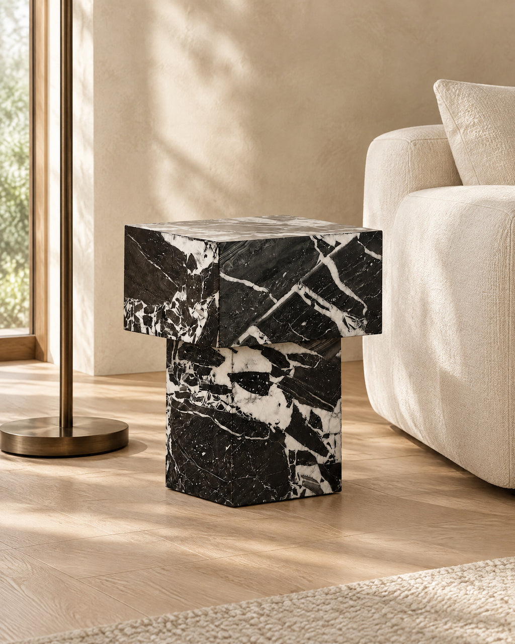 BUTTER side table by CARVINGS in Grand Antique Black Marble, in a styled living room, left view.