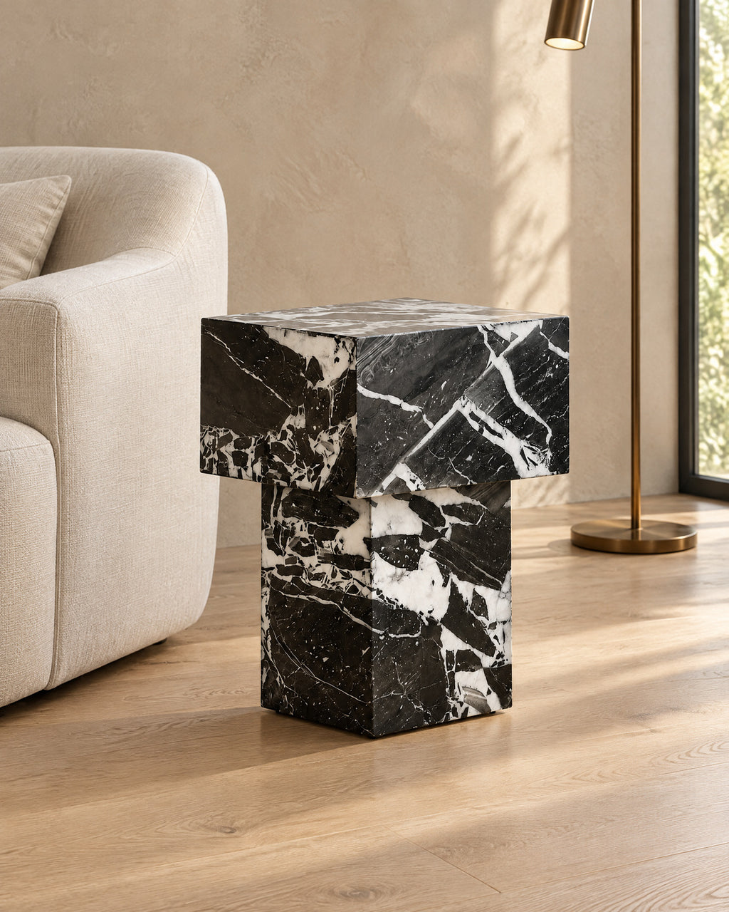 BUTTER side table by CARVINGS in Grand Antique Black Marble, in a styled living room, right view.