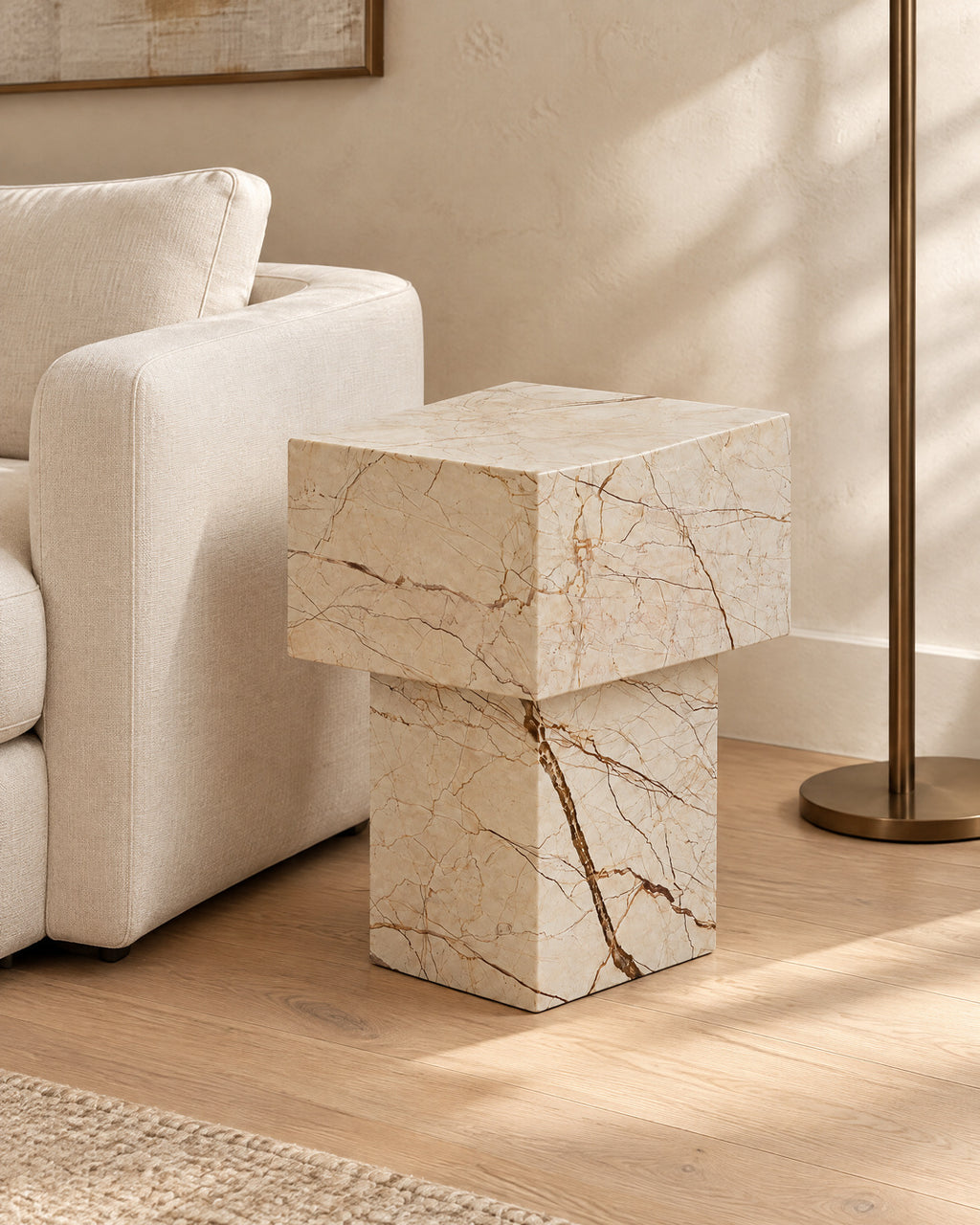 BUTTER side table by CARVINGS in Sofita Beige Marble, in a styled living room, right view.