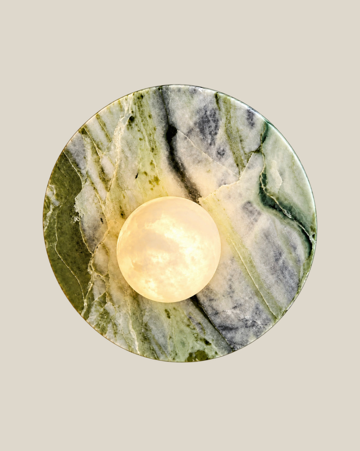 Front view of LUNETTE Wall Light in Ice Jade marble with an offset glowing globe.